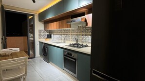 Una cocina moderna con horno empotrado, cocina a gas y refrigerador negro.