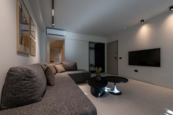 Relax in this stylish living room with a large sofa, coffee table, and flat-screen TV.