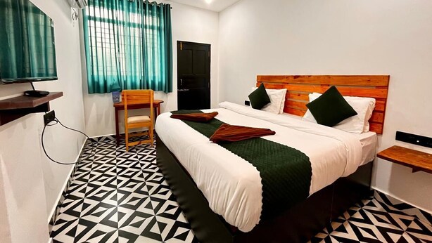 Une chambre d’hôtel avec un lit, une chaise, un bureau et un téléviseur.