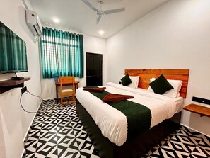 Une chambre d’hôtel avec un lit, une chaise, un bureau et un téléviseur.