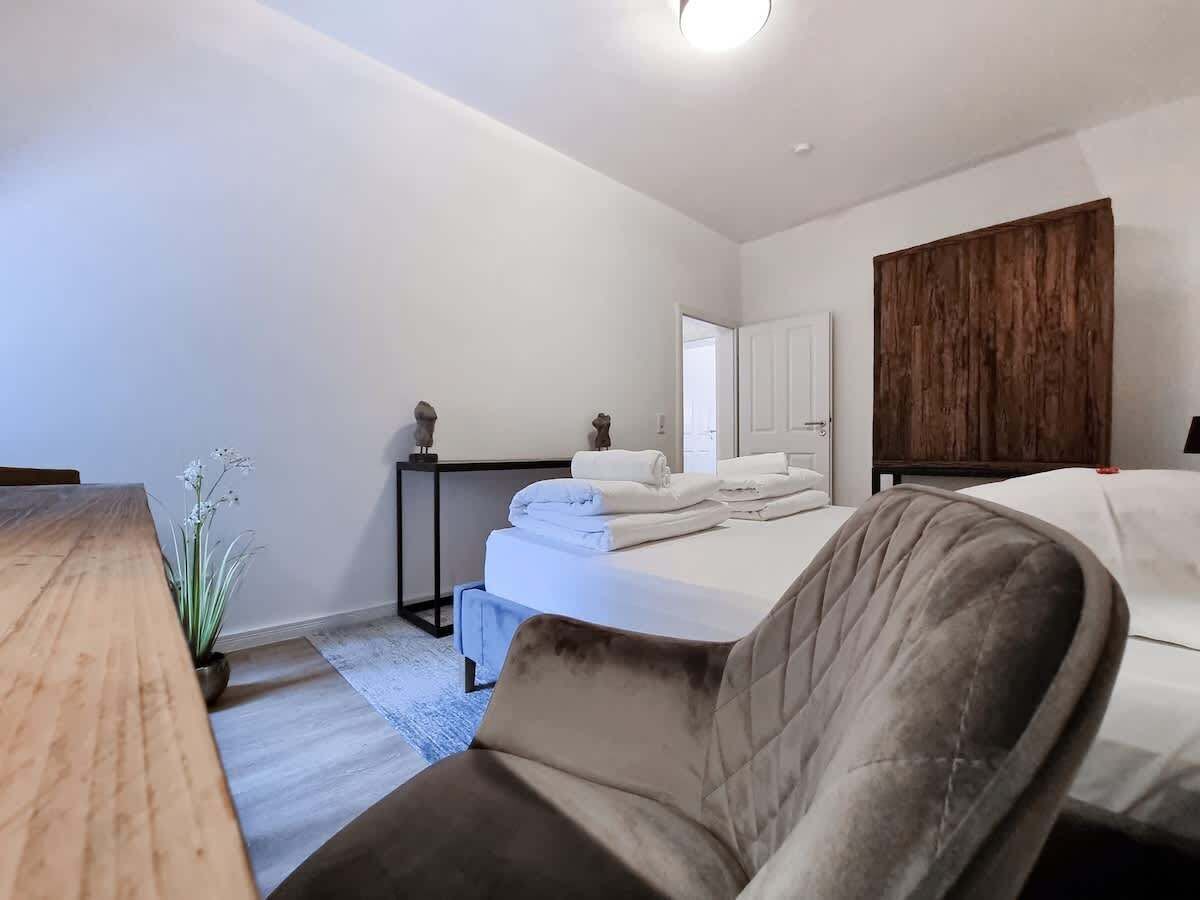 Ein Hotelzimmer mit einem Bett, einem Schreibtisch, einem Stuhl und einer Holzvertäfelung an der Wand.