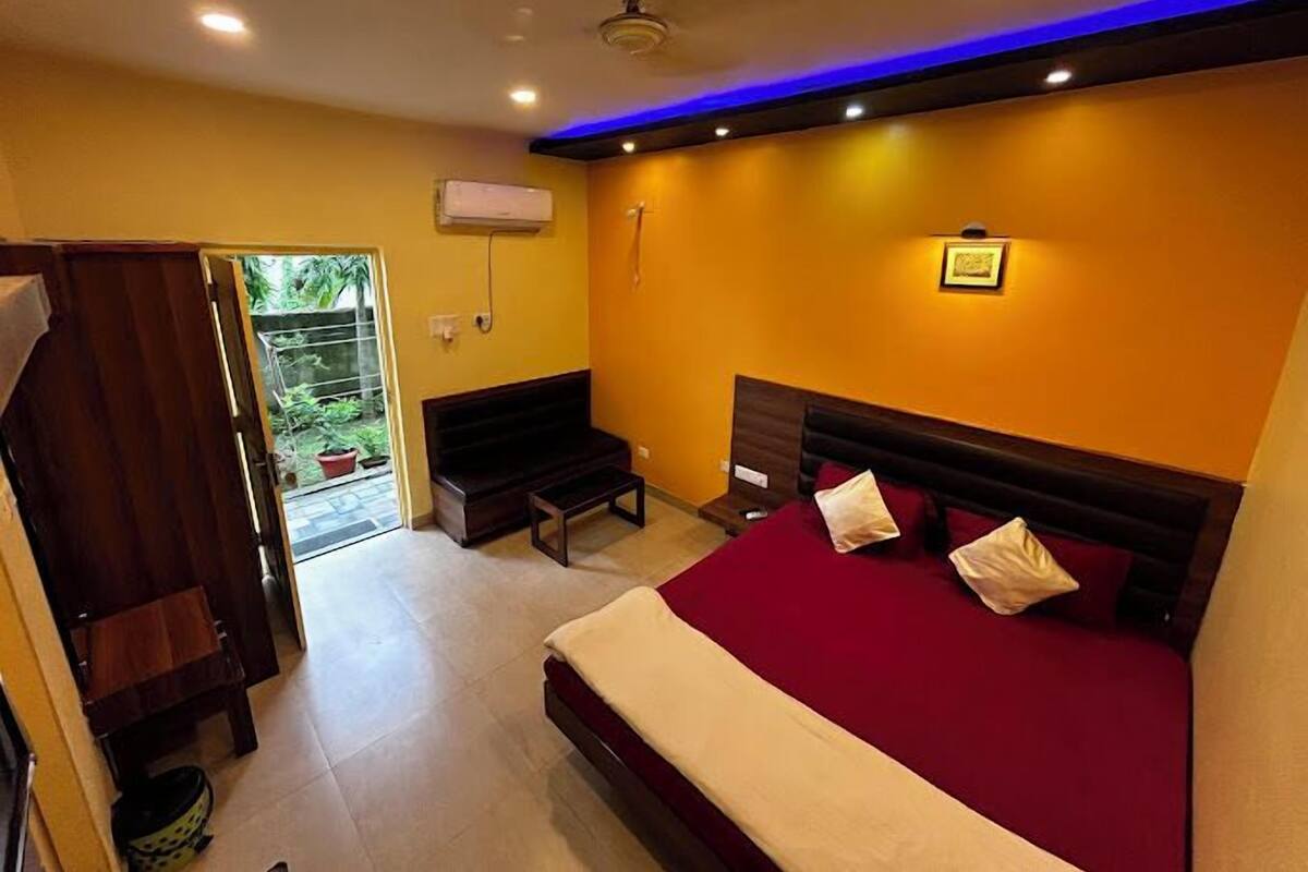Una habitación de hotel con una cama, un sofá, una mesita y un ventilador de techo.