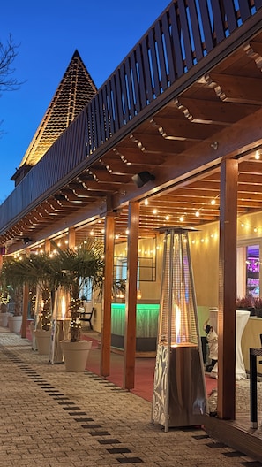 An outdoor covered area with a wooden structure, potted plants, and string lights. - Bootshaus Hamm (Hamm)