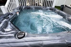 A hot tub with a built-in seat and a control panel.