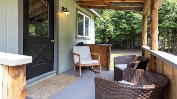 A covered porch with wicker furniture and a wooden bench. -  Private Adirondack Bear Retreat  (Athol)