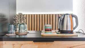 A kitchen counter with a kettle, glasses, and a decorative tree. - ApartHotel by PikHost (Shkodër)
