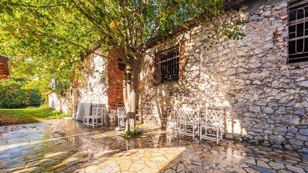 A stone building with a patio area featuring outdoor seating. - ApartHotel by PikHost (Shkodër)