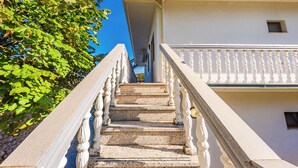 A staircase with white balustrades leading to a balcony. - ApartHotel by PikHost (Shkodër)