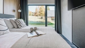 A modern hotel room with a large bed, a view of the outdoors, and a flat-screen TV mounted on the wall. - Wierchy View - Loft Affair Collection (Koscielisko)