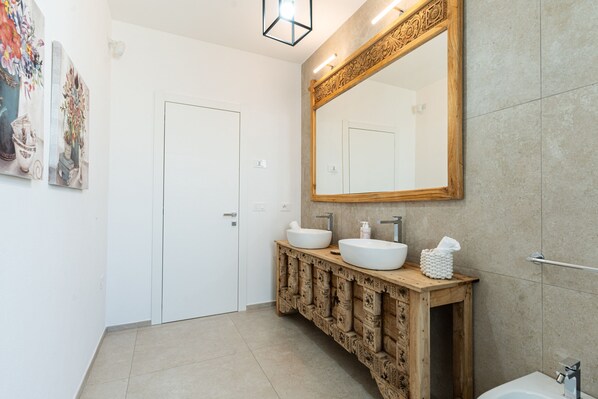 A modern bathroom with two sinks, a large mirror, and a wooden vanity. - Villa Infinity by Wonderful Italy (Olbia)
