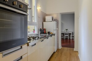 A modern kitchen with an oven, microwave, and sink. - Cozy Flat Orso Navona square (Roma)