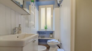 A bathroom with a sink, toilet, and window. - Cozy Flat Orso Navona square (Roma)