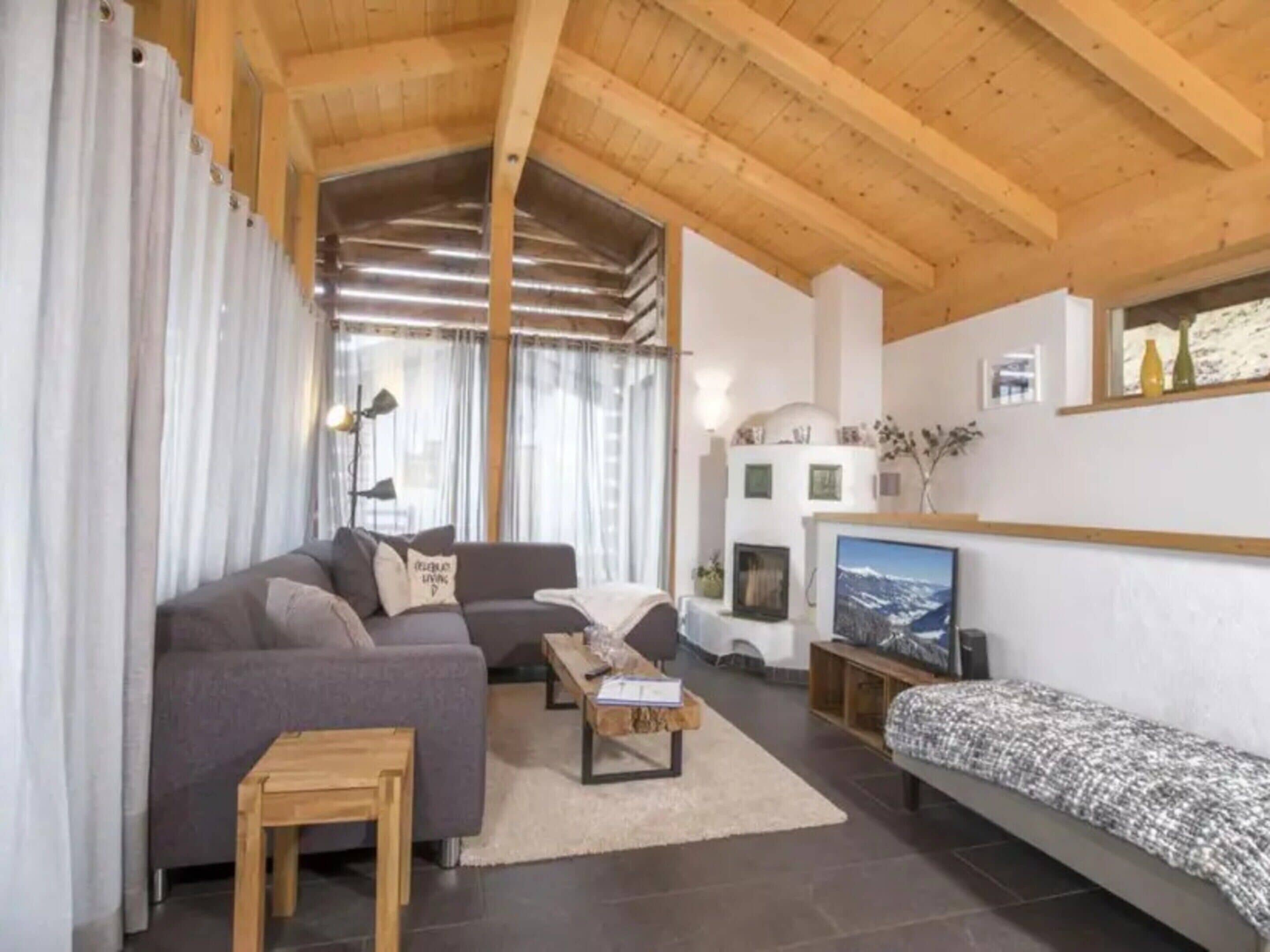 A cozy living room with a sofa, a coffee table, and a television.