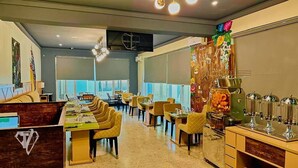 A modern dining area with a long counter, multiple chairs, and a buffet station. - Tribu Hotel (Enugu)
