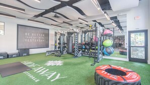 A gym with green artificial turf, weightlifting equipment, and a motivational quote on the wall. - Near TPC - Pool, Gym, Hot Tub Pickleball, WD (Scottsdale)