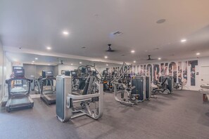 Une salle de sport équipée de tapis de course, d’appareils de musculation et d’autres équipements d’exercice.