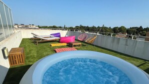 A rooftop with a hot tub surrounded by lounge chairs and a small grassy area. - Luxurious 5 pc + Jacuzzi + rooftop + terrace + air conditioning (Montpellier)