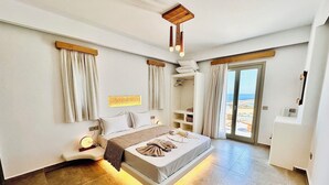 Un dormitorio espacioso con una cama grande, un vestidor amplio y un ventanal corredero que da a un balcón.