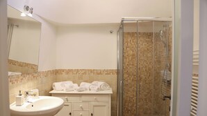 Une salle de bain avec un lavabo, un miroir et une douche.