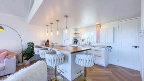 A modern kitchen with a central island, pendant lighting, and a white color scheme. - Modern Classic, Lake Views (Kincardine)