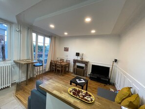 Ein Wohnzimmer mit Kamin, Essbereich und Fernseher.