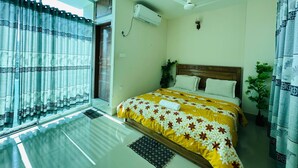 A bedroom with a bed, a ceiling fan, an air conditioning unit, and a window with curtains. - Hotel Nice Look Kuakata (Kalapara)