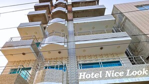A multi-story hotel with balconies, a staircase, and a sign reading "Hotel Nice Look". - Hotel Nice Look Kuakata (Kalapara)