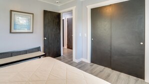 A bedroom with a bed, a bench, and two doors. - Hike, Fish & Boat: Secluded Mountain View Home (Mountain View)