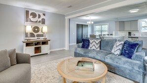 A modern living room with a grey sofa, a round coffee table, and a white cabinet with decorative items. - Hike, Fish & Boat: Secluded Mountain View Home (Mountain View)