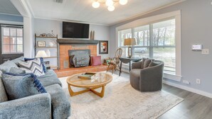A living room with a fireplace, a television, and a large window. - Hike, Fish & Boat: Secluded Mountain View Home (Mountain View)