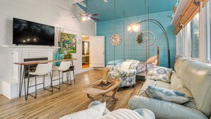 A living room with a fireplace, a TV, a dining area with chairs, a sofa, and a hanging light fixture. - 4 Mi to Falls Lake: Dog-friendly Wake Forest Home (Wake Forest)
