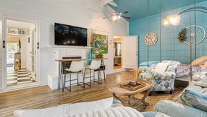 A living room with a fireplace, a television, and a dining area with chairs. - 4 Mi to Falls Lake: Dog-friendly Wake Forest Home (Wake Forest)