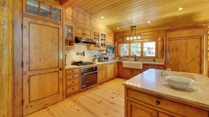 A spacious kitchen with wooden cabinets, a large island, and a stone countertop. - Sun Valley Log Home w/ Hot Tub & Mtn Views! (Sun Valley)