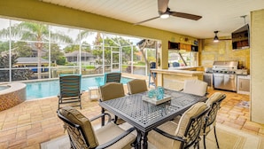 An outdoor patio with a pool, seating, and a grill area. - On-site Canal Access: Luxe Home in Palm Coast! (Palm Coast)