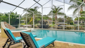 An indoor swimming pool with lounge chairs and a glass enclosure. - On-site Canal Access: Luxe Home in Palm Coast! (Palm Coast)