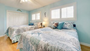 A bedroom with two beds, a ceiling fan, a nightstand with a lamp, and a window with blinds. - Golf Getaway w/ Pool Access: Little River Home! (Little River)