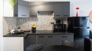 A modern kitchen with grey cabinets, a black refrigerator, a microwave, and a sink with a plant and a coffee maker on the counter. - [Piazza Erbe] In city center up to 4 guests with parking (Verona)