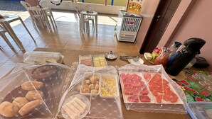 Ein Buffet mit verschiedenen Speisen, die mit Frischhaltefolie abgedeckt sind.