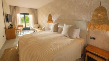 A large bed with a textured bedspread, a wooden nightstand, and a hanging light fixture.