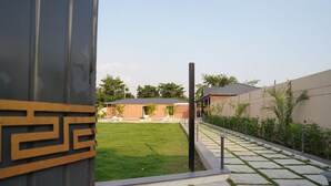 Un cortile con un vialetto lastricato, un prato verde e un edificio con tetto in tegole.