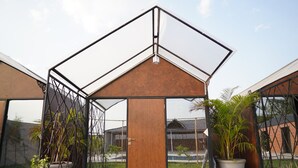 Un edificio moderno con struttura metallica geometrica e una porta in legno.