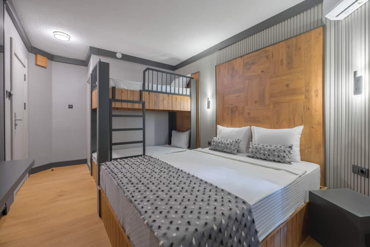 Een moderne slaapkamer met een stapelbed, een houten hoofdbord en een nachtkastje.