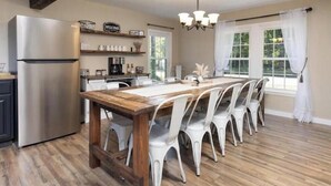 A modern kitchen with a central island, white chairs, a stainless steel refrigerator, and a chandelier. - High Street Hideaway (Athol)