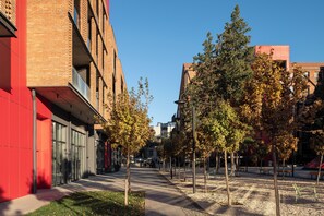 Eine moderne Stadtstraße mit Gebäuden, Bäumen und Bänken.