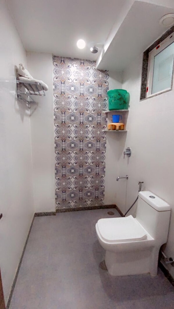 A small bathroom with a toilet, a shower, and a sink. - Hotel Majesty inn (Jaipur)