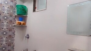 A bathroom with a toilet, sink, and a small window. - Hotel Majesty inn (Jaipur)