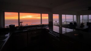 A modern kitchen with large windows overlooking a sunset view. - Gorgeous beachfront house with stunning views, light and the sounds of the ocean (Manhattan Beach)