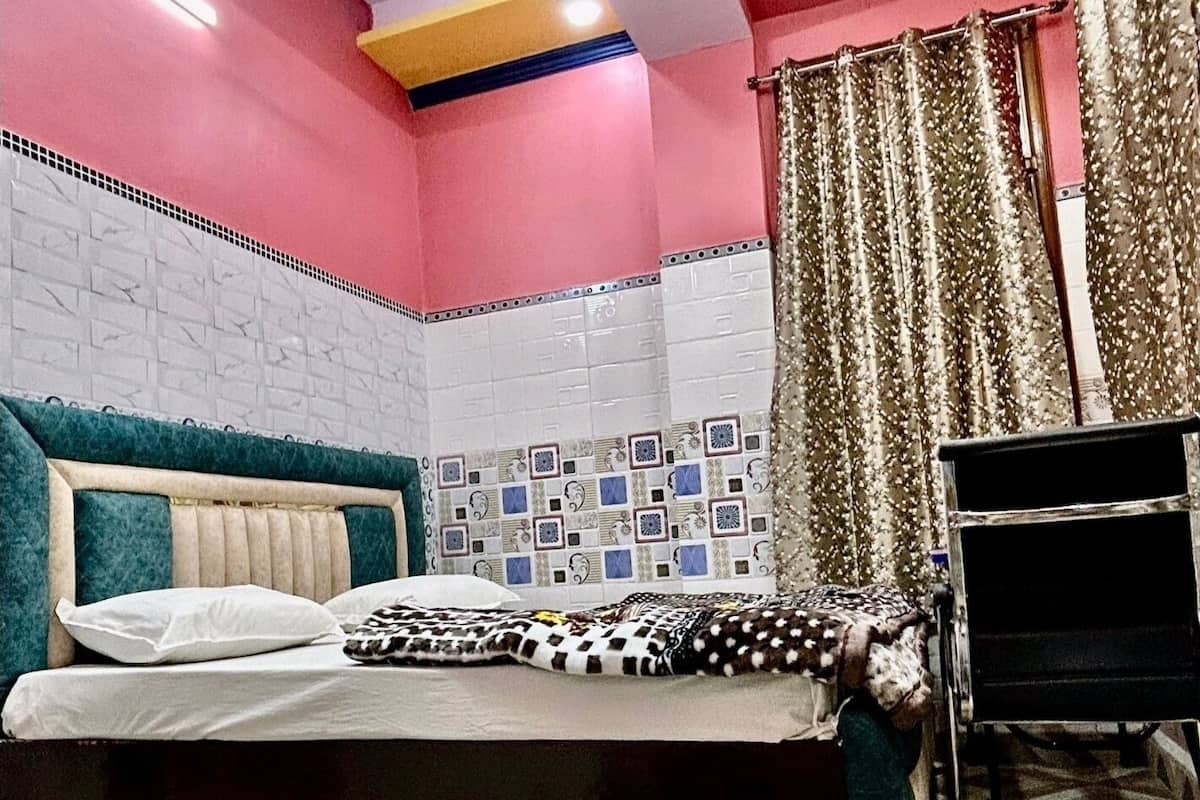 A bedroom with a bed, a desk, and a ceiling fan.