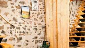 A rustic room with a stone wall, a wooden staircase, and a 'General Store' sign. - Ch. d'hôtes La clef des champs - THE SOURCE OF OUR ROOTS - FERMETTE - AVESNOIS (Beaufort)