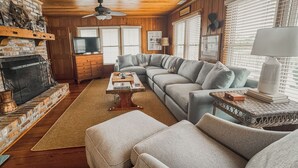 Ein gemütliches Wohnzimmer mit Kamin, einem Ecksofa und einem Couchtisch.
